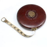 Vintage tape measure with leather case on a white background