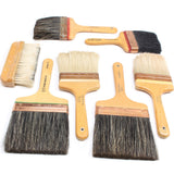 Set of large paint brushes with wooden handles on a white background