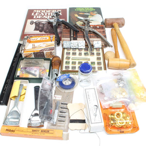 Collection of leatherworking tools and materials on a white background